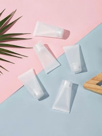 a set of plastic tubes on a pink and blue background